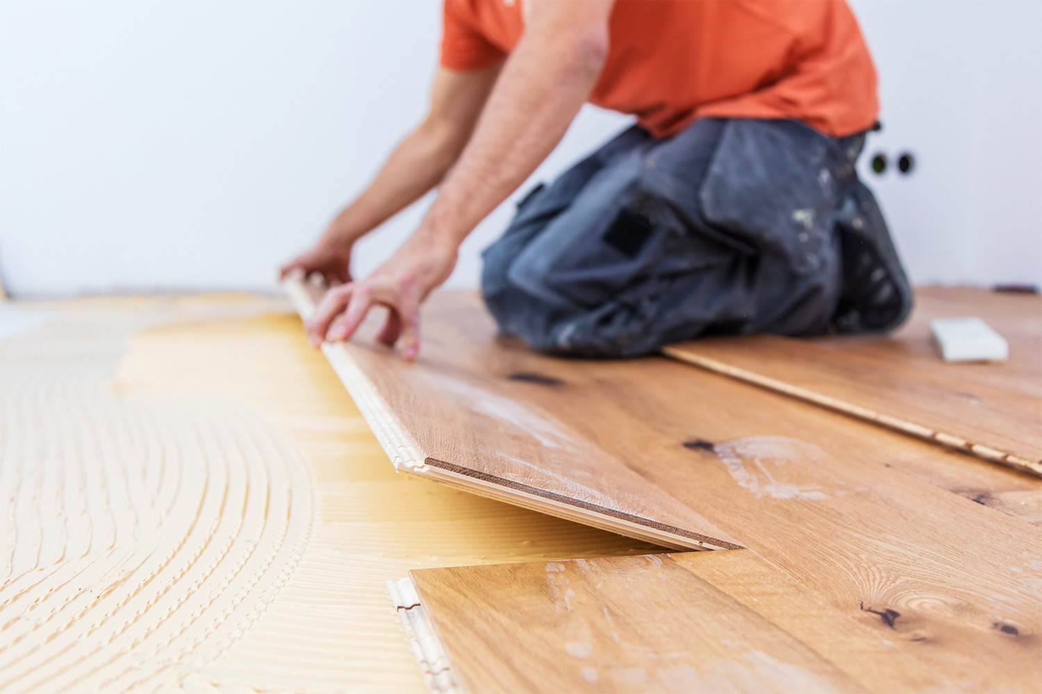 Arbeiter verlegt Holzlaminat auf dem Fußboden